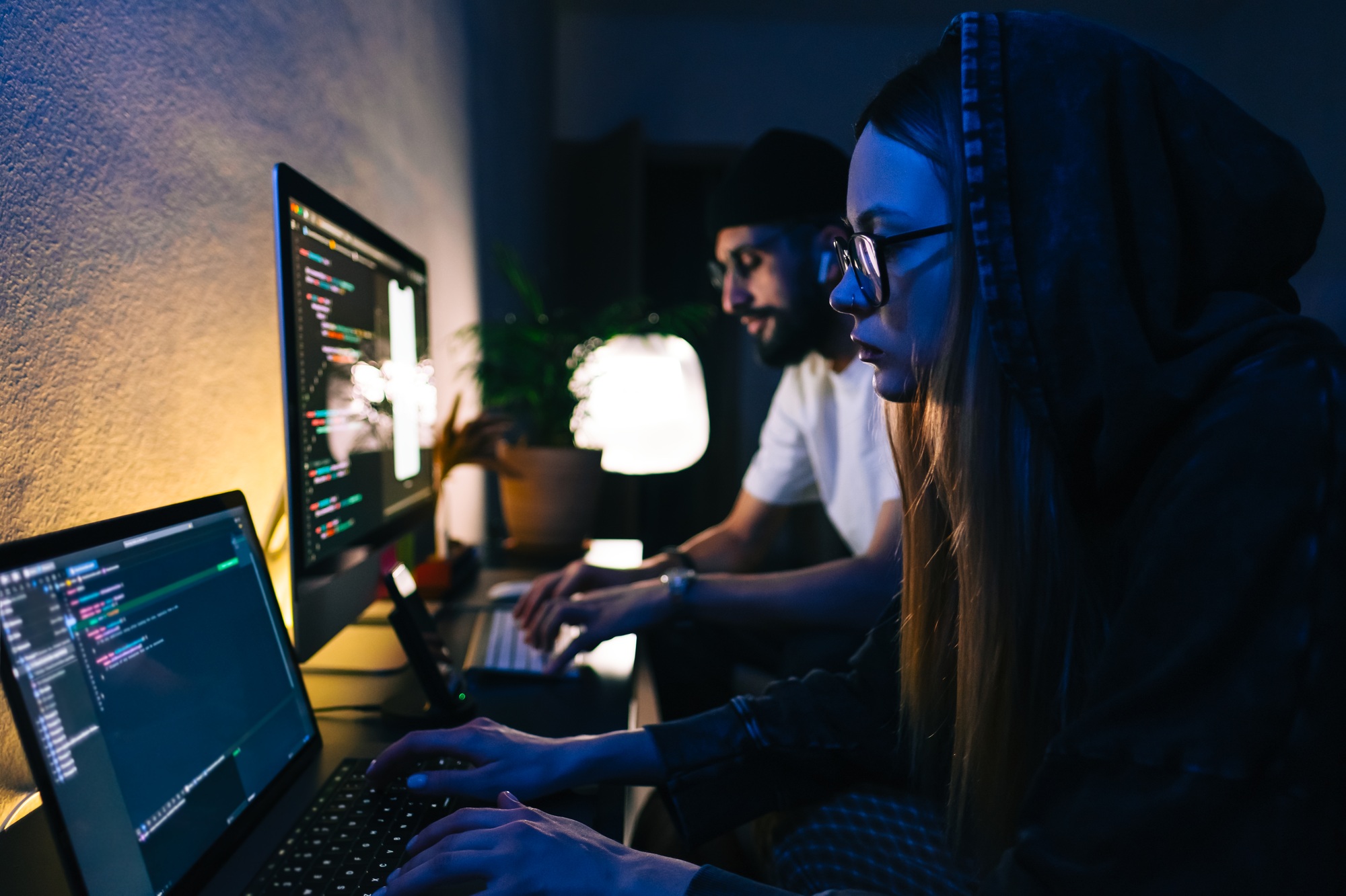 Mobile developers team writes program code on a computer, programmers work in home office.